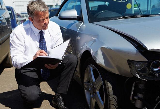 smiling person holding car insurance card